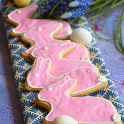 Ostergebäck, Osterhäschen ohne Fructose mit fructosefreiem Royal Icing auf Holzbrett mit rosa Glasur