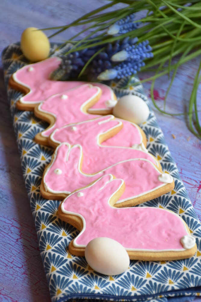 Ostergebäck, Osterhäschen ohne Fructose mit fructosefreiem Royal Icing auf Holzbrett mit rosa Glasur