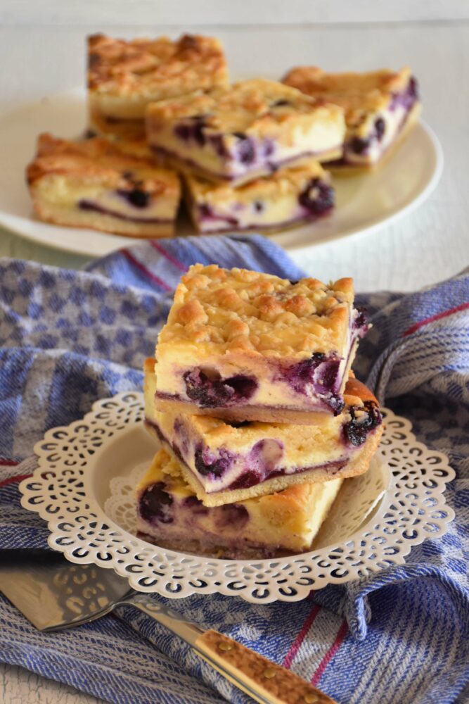 Heidelbeer-Topfen-Streuselkuchen, fructosearm, auf Teller mit blauem Tuch