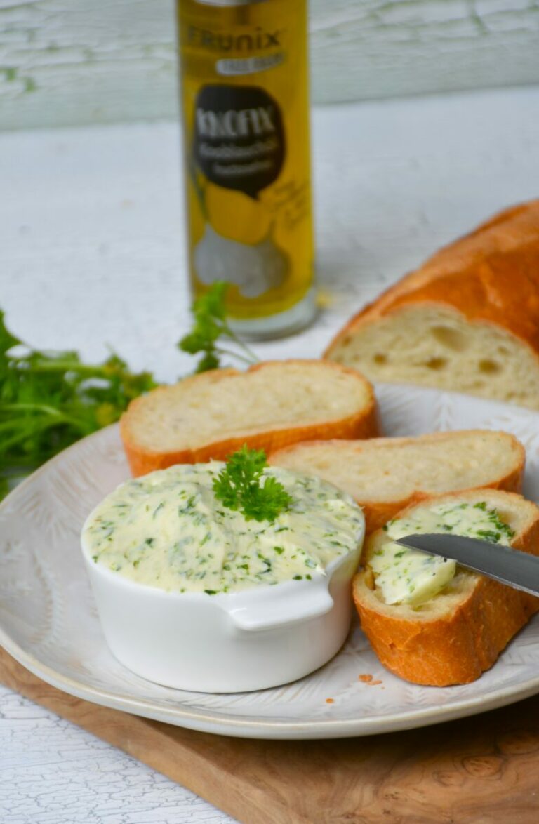 Kräuterbutter ohne Fructose mit KNOFIX-Knoblauchöl, bestrichenes Weißbrot auf Holzbrett