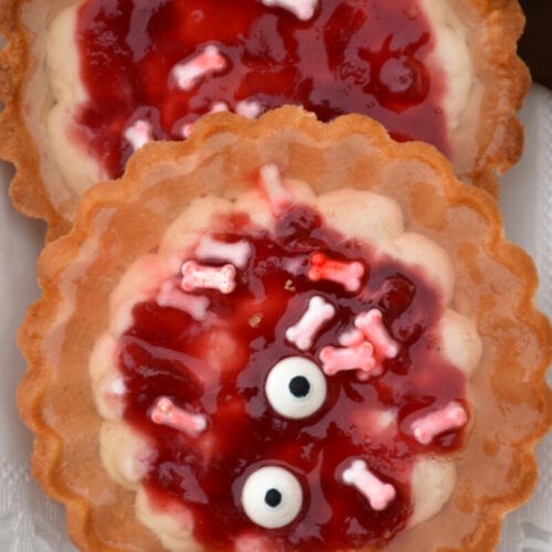 Halloweentörtchen, gruselig mit Topfenfülle, roter Marmelade und Zuckerkonochen, Zuckeraugen