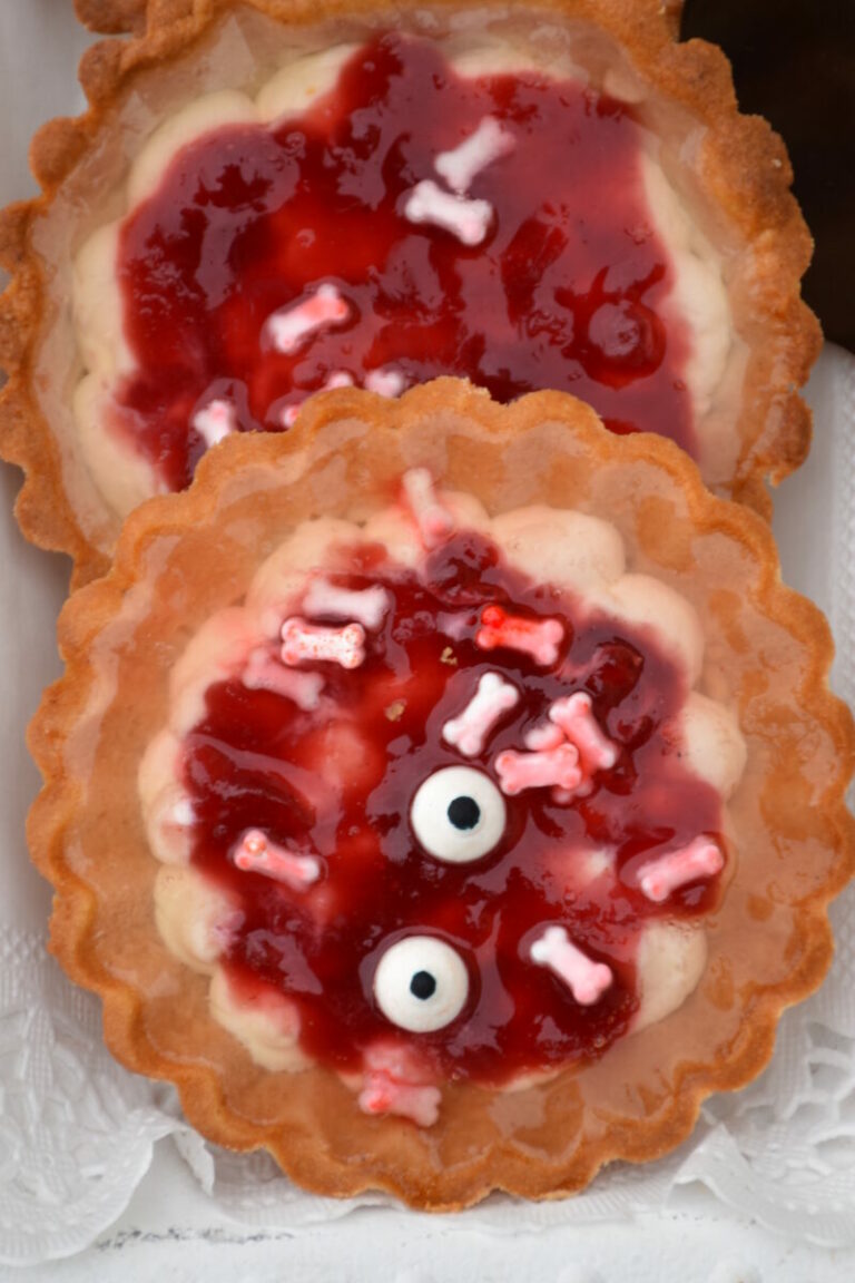 Halloweentörtchen, gruselig mit Topfenfülle, roter Marmelade und Zuckerkonochen, Zuckeraugen