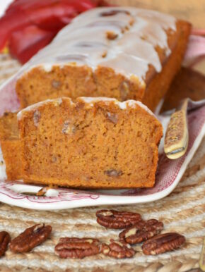 Kürbiskuchen ohne Gluten, ohne Fructose, ohne Milch auf einer Kuchenplatte mit Herbstdeko.