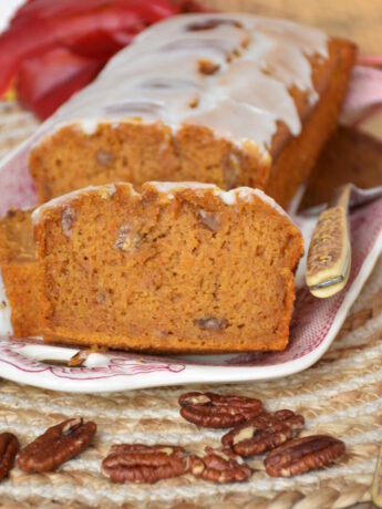 Kürbiskuchen ohne Gluten, ohne Fructose, ohne Milch auf einer Kuchenplatte mit Herbstdeko.