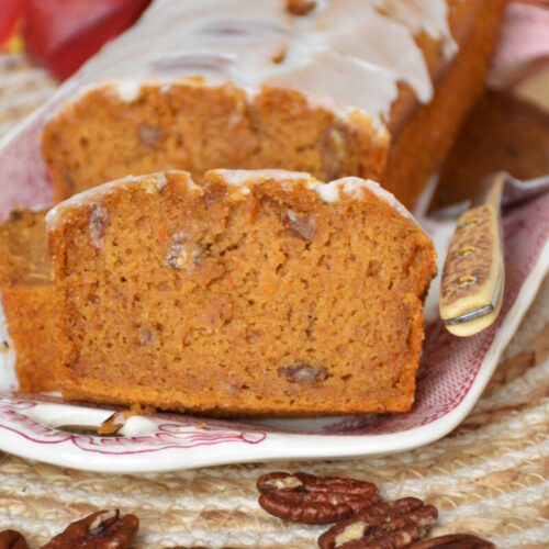 Kürbiskuchen ohne Gluten, ohne Fructose, ohne Milch auf einer Kuchenplatte mit Herbstdeko.