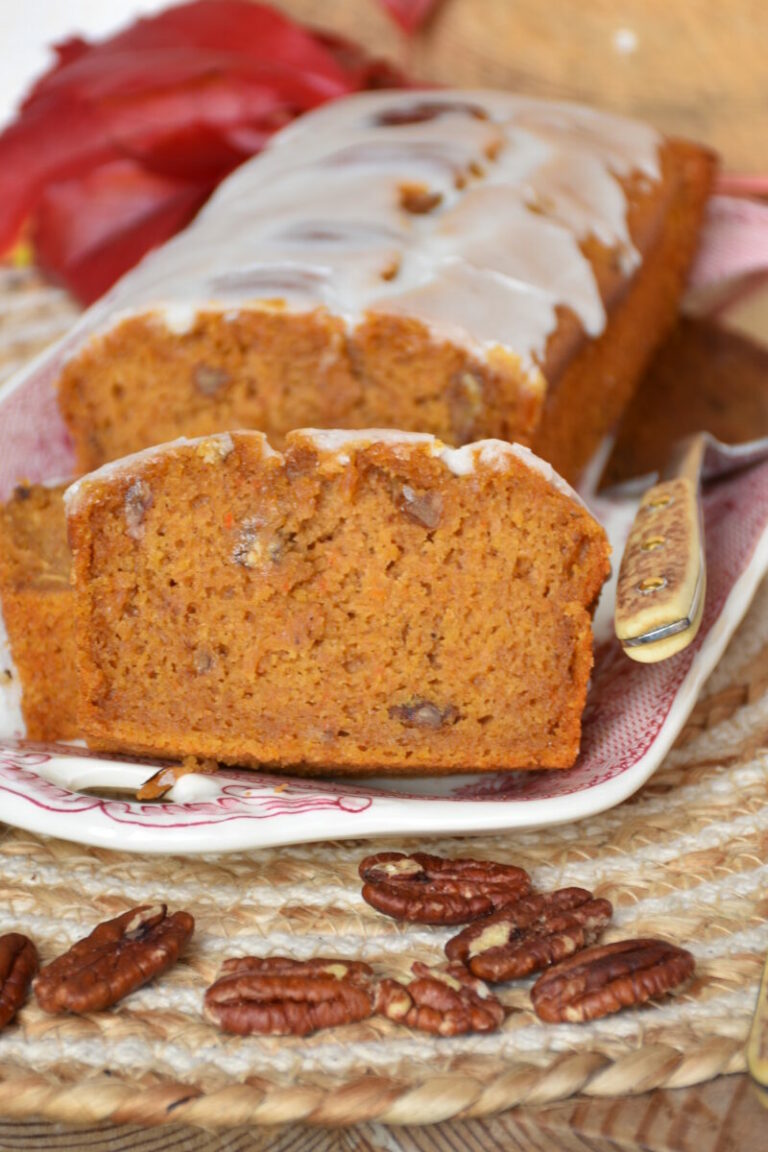 Kürbiskuchen ohne Gluten, ohne Fructose, ohne Milch auf einer Kuchenplatte mit Herbstdeko.