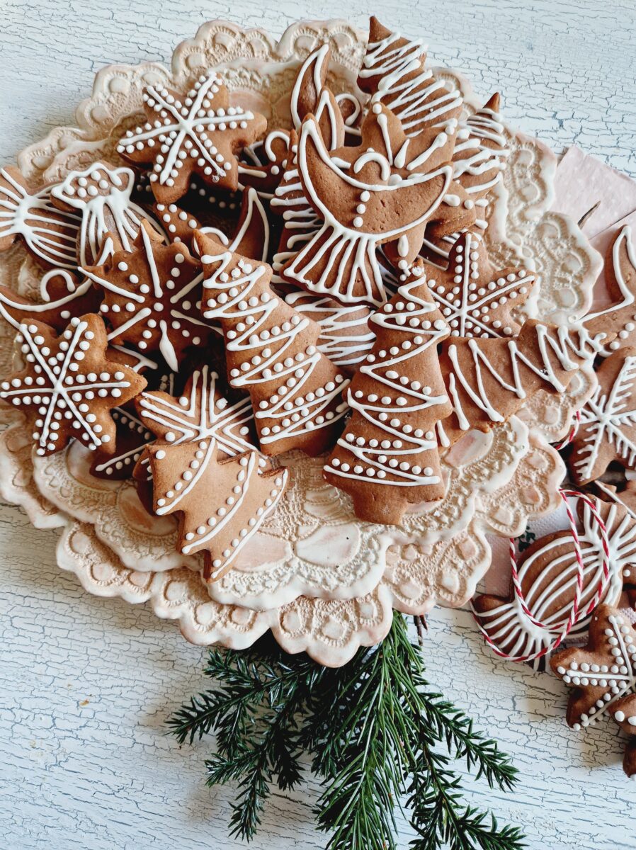 Lebkuchen ausgestochen inverschiedenen Formen mit Zitronenglasur verziert auf rosa Spitzenteller