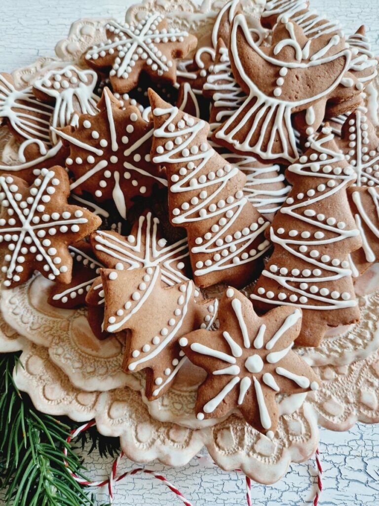 Lebkuchen ausgestochen inverschiedenen Formen mit Zitronenglasur verziert auf rosa Spitzenteller